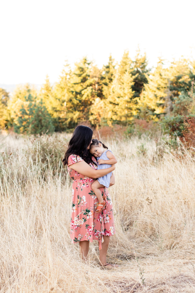 Portland OR mommy and me session in a local park featuring mother and daughter snuggled together