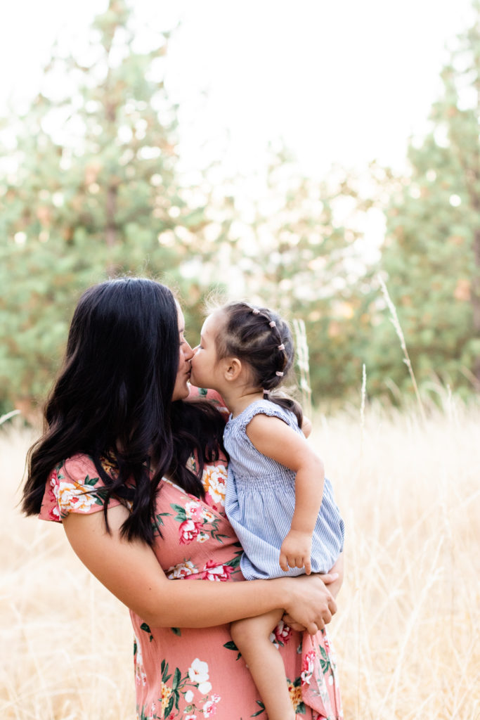 Portland OR mommy and me session in a local park featuring mother and daughter snuggled together and giving kisses
