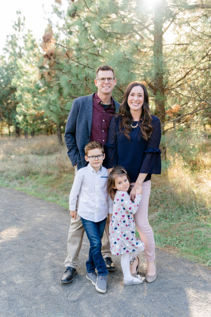 a beautiful oregon family session with ponderosa pine tress and the sun shining through featuring a father, mother, son and daughter